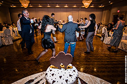 Michelle dances with family and friends at her bridal shower party, with the beautiful cake in the foreground.